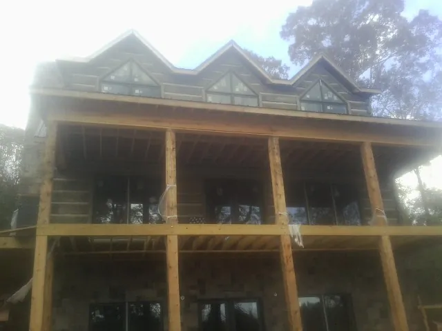 Dormers and porch framing on a large log home under construction — Roof Coating work by our crew in Kenosha