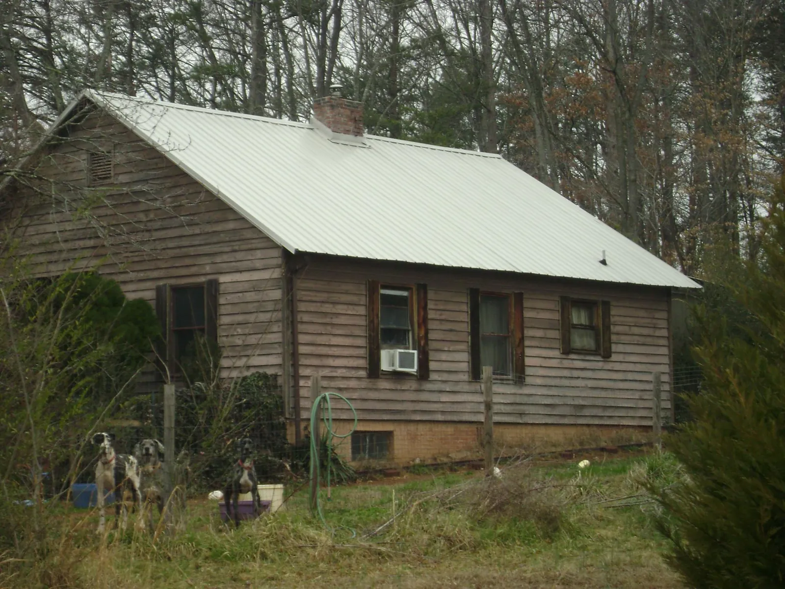 White metal roof on an old wood sided farmhouse, from a Metal Roof Installation job in Kenosha